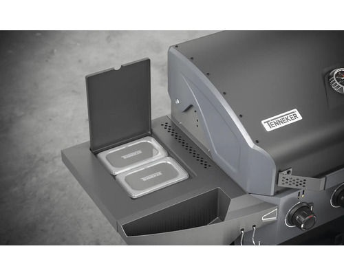 Prim-plan al unui grătar pe gaz cu grătar de încălzire deschis și logo-ul Tenneker.