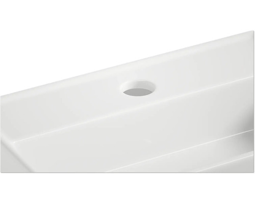 Prim-plan cu o chiuvetă albă cu orificiu pentru robinet