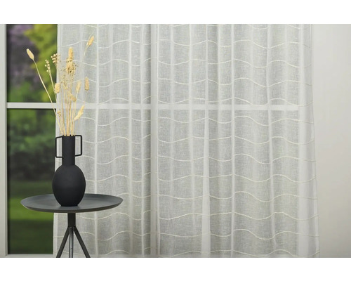 Material decorativ, transparent, pentru perdele, cu model ondulat în fața unei ferestre