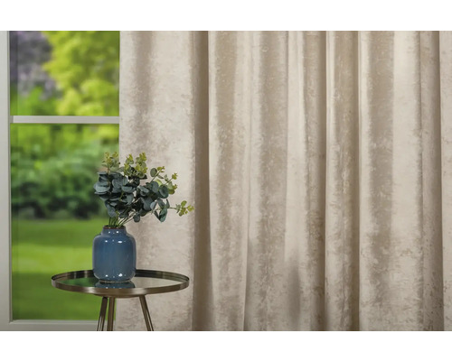 Cortină decorativă lângă o masă cu o vază de flori în fața ferestrei.