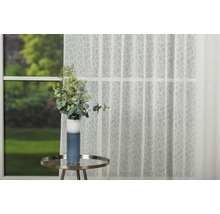 Fereastră decorativă cu perdea transparentă, masă și vază de flori.