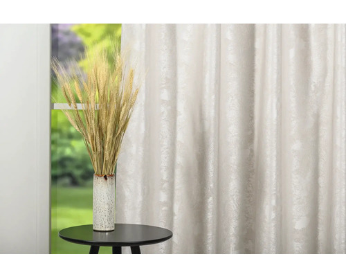 Aranjament decorativ cu spice de grâu în vază pe masă în fața perdelei