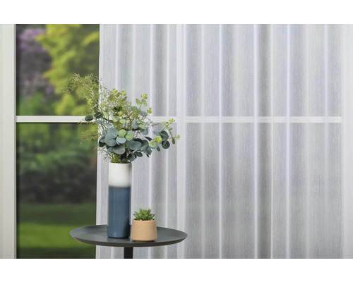 Aranjament decorativ cu perdea, masă și vază de flori în cameră