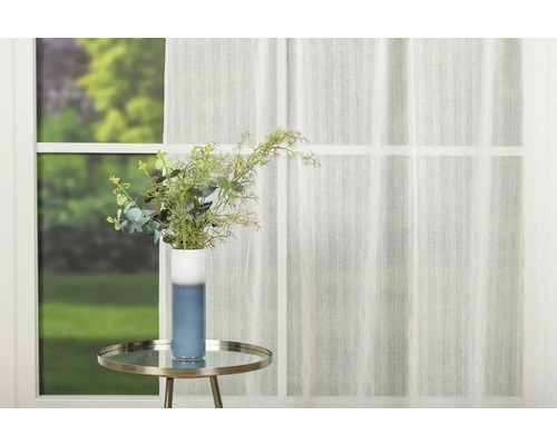 Scenă decorativă cu perdea transparentă, măsuță laterală și vază cu flori