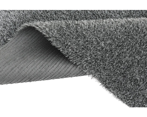 Gazon artificial gri cu un colț rulat care arată partea din spate