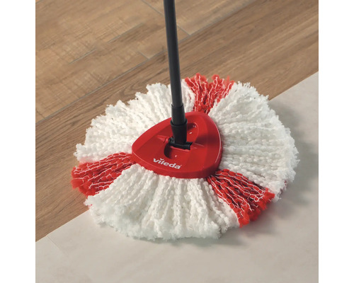 Sigla Vileda pe un mop cu husă roșie și albă pe o podea