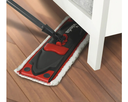 Mop sub o piesă de mobilier pe podea de lemn