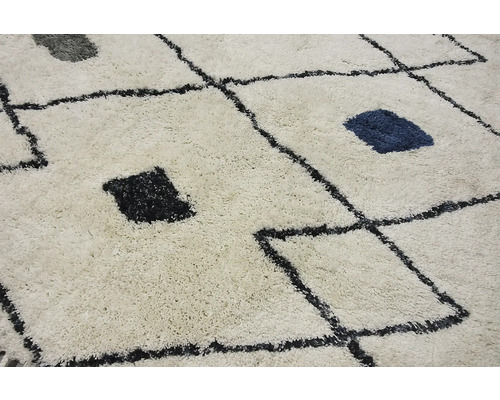 Prim-plan al unui covor cu model geometric și franjuri