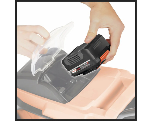 Un bărbat introduce o baterie într-o mașină de tuns iarba.