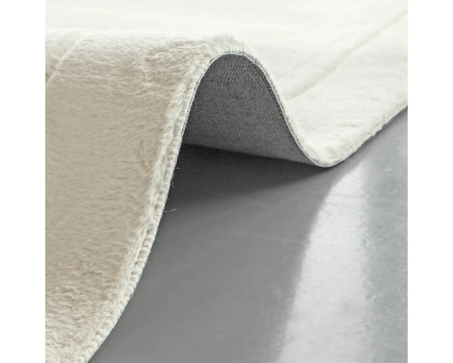 Prim-plan cu un covor de culoare deschisă, cu față și spate