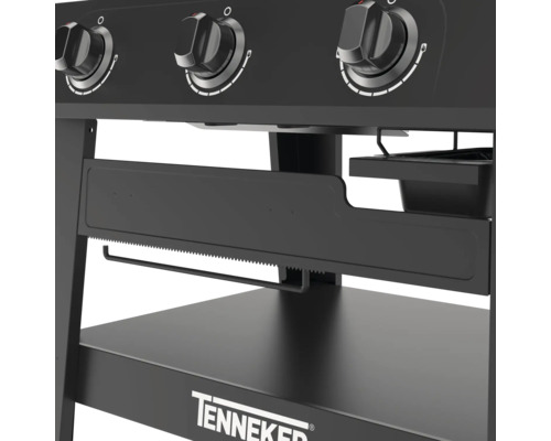 Imagine detaliată cu un grătar pe gaz negru, cu butoane rotative, suport pentru prosoape de hârtie și spațiu de depozitare, marca Tenneker.