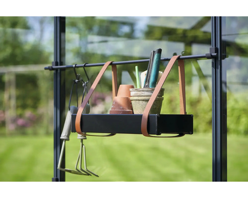 Raft suspendat cu unelte de grădinărit și ghivece în fața unui panou de sticlă