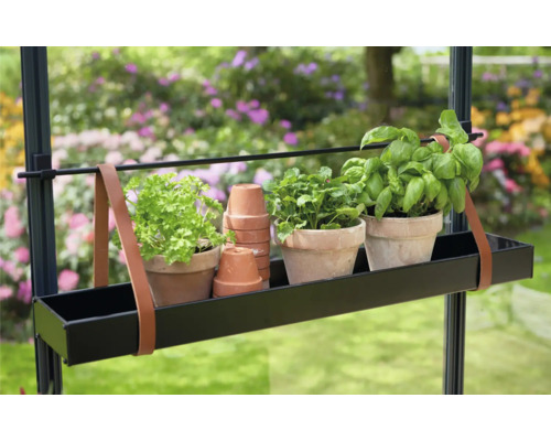 Jardinieră cu ierburi și ghivece de teracotă stivuite într-o grădină