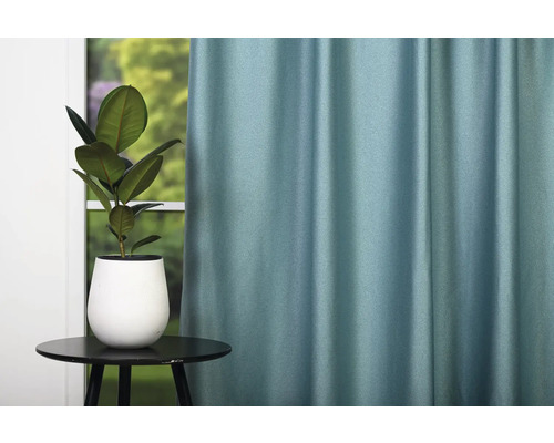 Cameră decorativă cu perdea, masă și plantă de interior pentru o atmosferă primitoare.