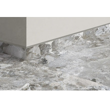 Prim-plan al unei încăperi cu gresie și plintă cu aspect de piatră