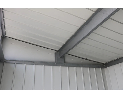 Vedere interioară a unei magazii de grădină cu acoperiș metalic și grinzi de oțel