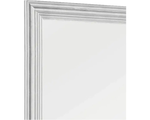 Prim-plan al unei oglinzi cu ramă profilată.