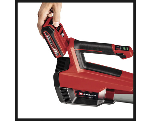 Vedere de sus a unui aspirator/suflător de frunze cu acumulator Einhell, unde o mână introduce un acumulator.