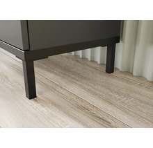 Prim-plan cu un corp de mobilier de baie cu picioare metalice pe podea de lemn.