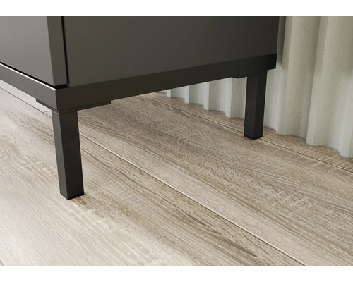 Prim-plan cu un corp de mobilier de baie cu picioare metalice pe podea de lemn.