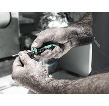 O persoană ține o șurubelniță Wera în mână.