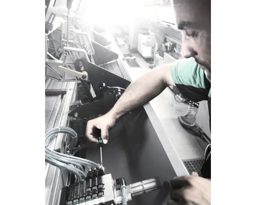 Un bărbat repară o mașină cu o șurubelniță.