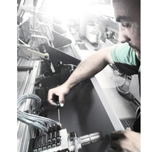 Un bărbat lucrează cu o șurubelniță la o mașină.