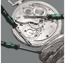 Șurubelnițe de precizie în fața mecanismului unui ceas de buzunar