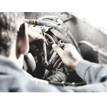 Mecanic cu chei în timpul reparației unui motor