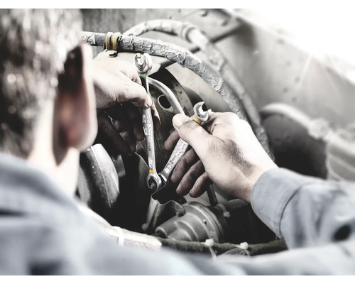 Mecanic cu chei în timpul reparației unui motor