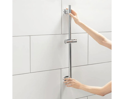 Persoană care montează o bară de duș în baie