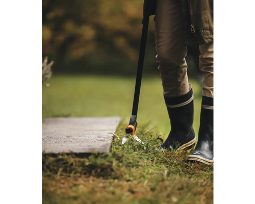 Persoană care folosește o foarfecă de gazon cu mâner pentru întreținerea gazonului