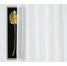 Cortină decorativă, transparentă, în fața unui decor de perete cu motiv vegetal