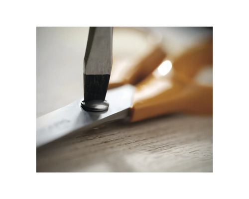 Prim-plan cu o foarfecă pe o masă din lemn