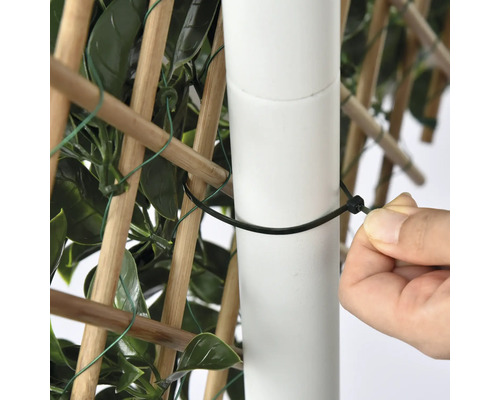 Prim-plan cu o persoană care fixează un paravan de confidențialitate de un stâlp cu o legătură de cablu.