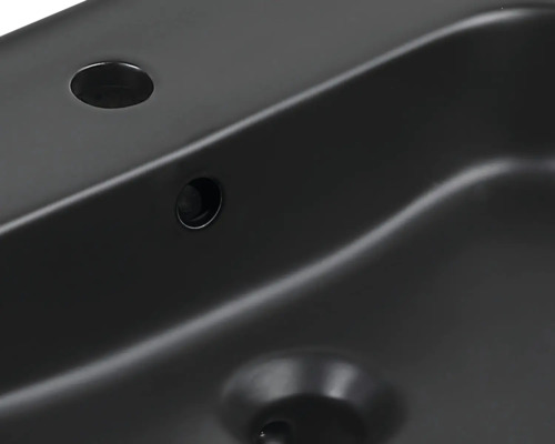 Imagine detaliată a unei chiuvete negre cu orificiu pentru robinet și preaplin