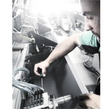 Un bărbat repară o mașină cu o șurubelniță.