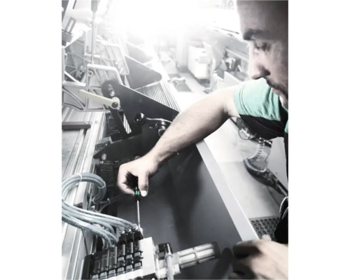 Un bărbat repară o mașină cu o șurubelniță.