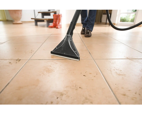 Curățare podea cu un aspirator cu spălare pe o podea cu gresie