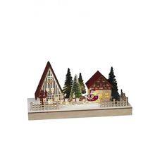 Scenă decorativă de Crăciun cu case, pomi și Moș Crăciun într-o sanie.