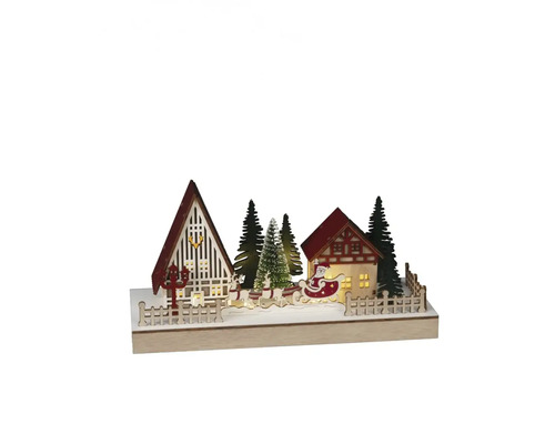 Scenă decorativă de Crăciun cu case, pomi și Moș Crăciun într-o sanie.