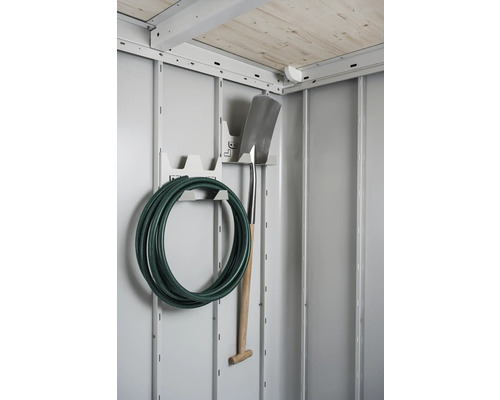 Furtun de grădină și lopată pe un suport de scule într-o magazie de grădină