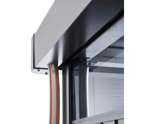 Prim-plan al unei grădini de iarnă cu elemente metalice și racord de furtun