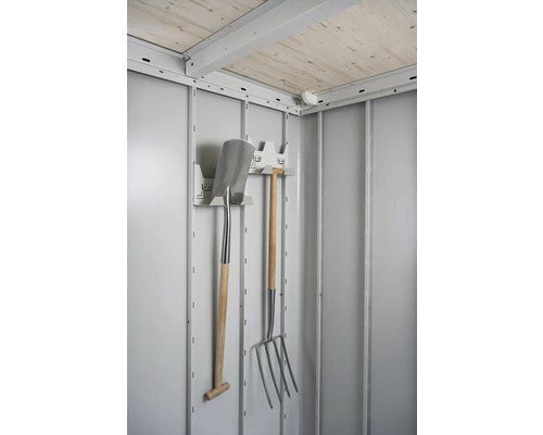 Imagine de interior a unei magazii de grădină cu unelte de grădină, cum ar fi o lopată și o furcă de gunoi, pe un suport