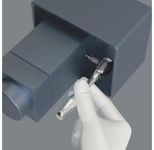 O mână folosește o cheie tubulară cu bit pentru a înșuruba.