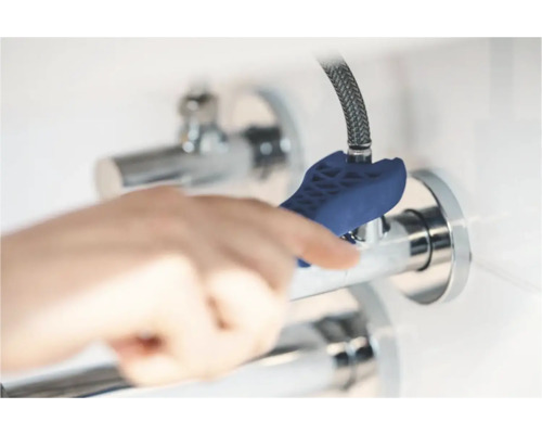 O mână folosește o cheie de robinet pentru instalarea unui robinet.