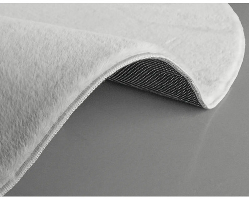 Prim-plan cu un covor alb cu fibre și spate textil