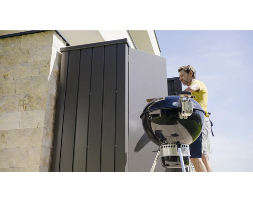 Persoană pregătind grătarul, spațiu de depozitare în fundal