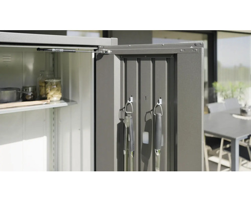 Vizualizare detaliată a unui dulap de grădină deschis, cu rafturi și suport pentru ustensile de grătar.