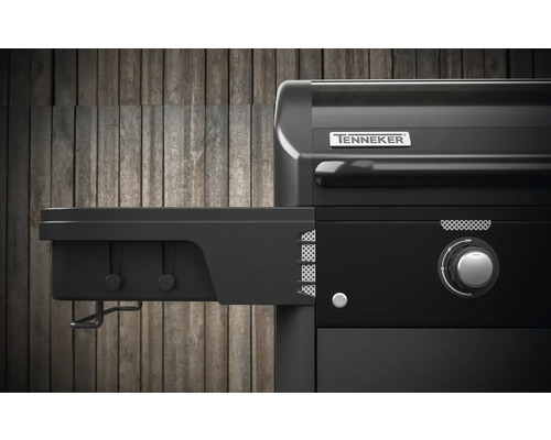 Imagine detaliată cu un grătar pe gaz negru cu raft lateral și sigla Tenneker.